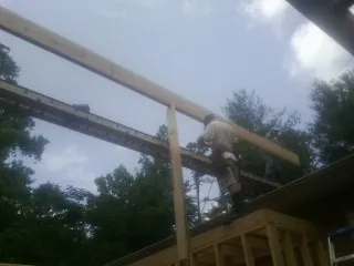 Carpenter setting a ridge beam over a new addition frame — Ice Dam Removal by Roofing Brothers in New Lisbon