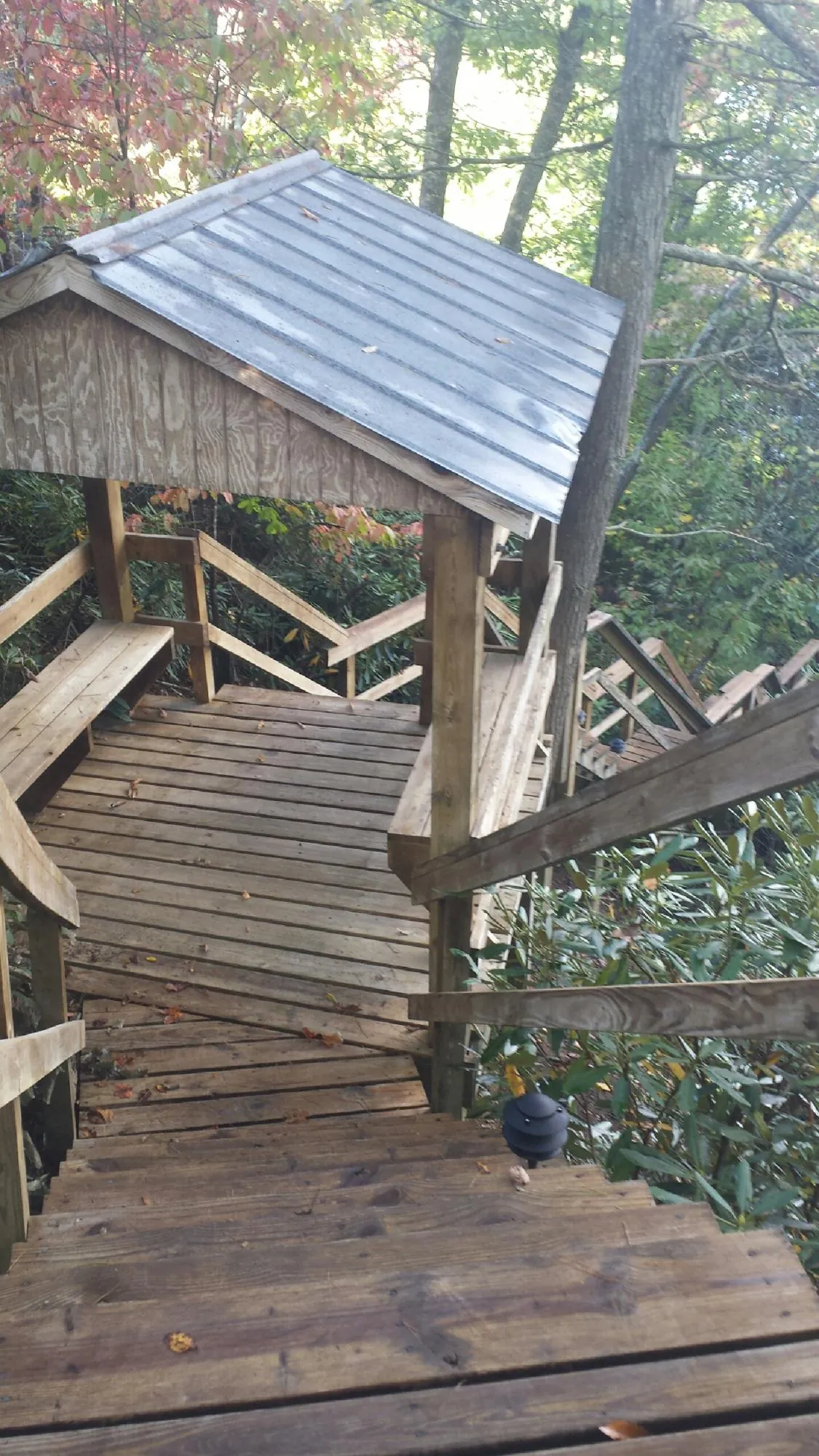 Metal roofed shelter over wooden steps on a wooded walkway — Skylight Repair & Installation work by our crew in New Lisbon
